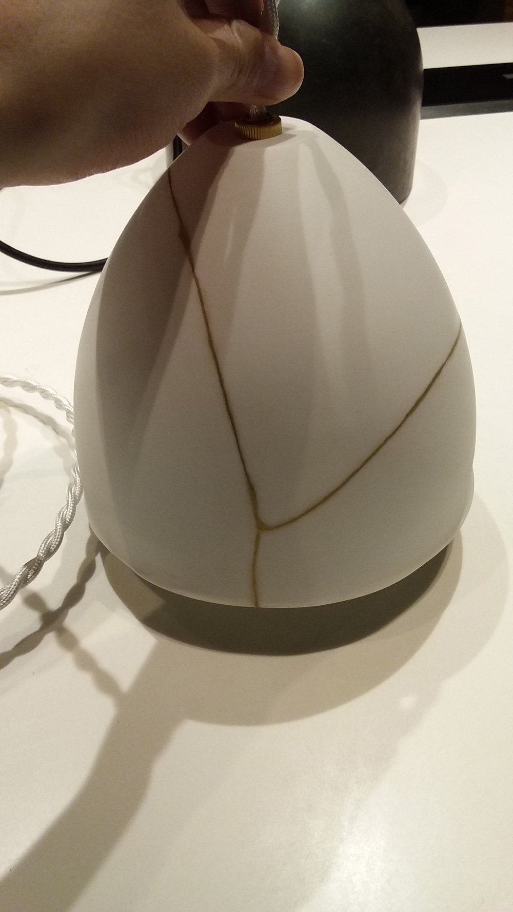 NEW LIGHT POTTERYの「Kintsugi」は、接着部分を金で装飾する修復技術「金継ぎ」を磁器製のシェードに施した照明。