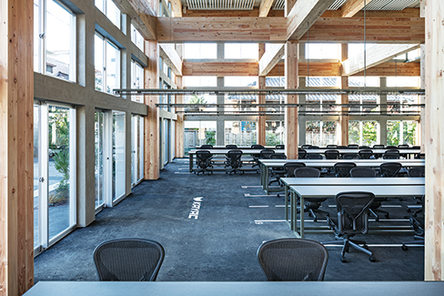 研究開発棟1階執務室。8m強の天井の高さを持つワンフロアで、木造柱や梁が空間を構成する（撮影／長谷川健太）