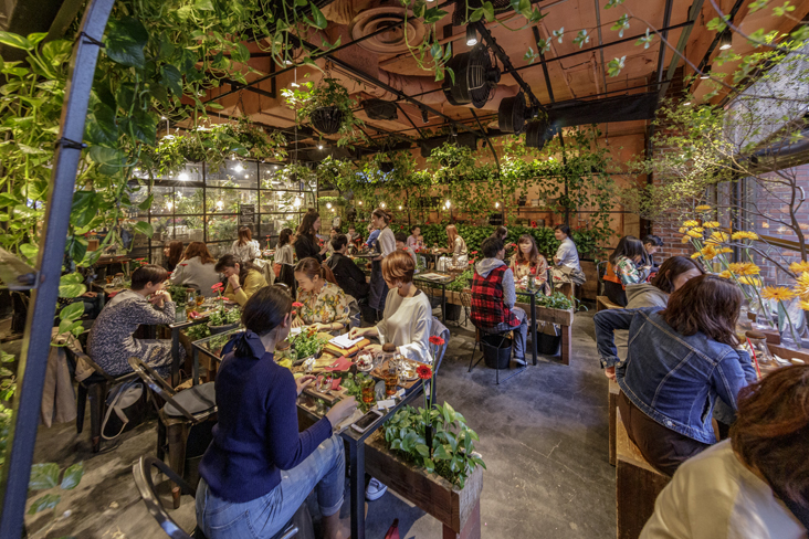 カフェ「Aoyama Flower Market TEA HOUSE」。温室をコンセプトとした、花と緑に囲まれた空間で飲食を楽しめる