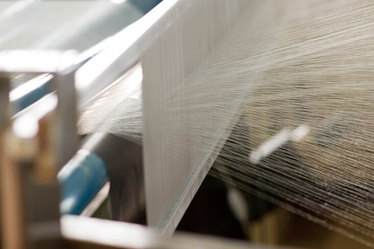 織物と紙を貼り合わせてつくられる織物壁紙。一本の糸から織りなす温かさと高級感で上質な空間に仕上げる。天然素材の糸とリサイクル紙を使用し、人と地球にも優しい