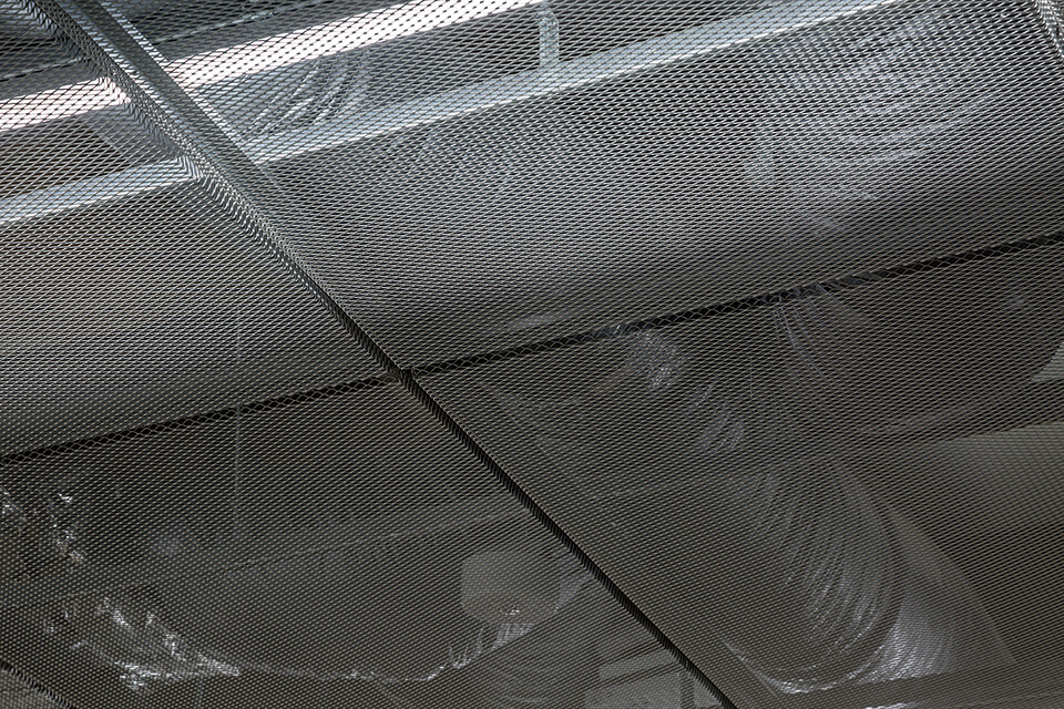 エントランスの天井。繊細なメッシュがダクト設備を視覚的に遮る