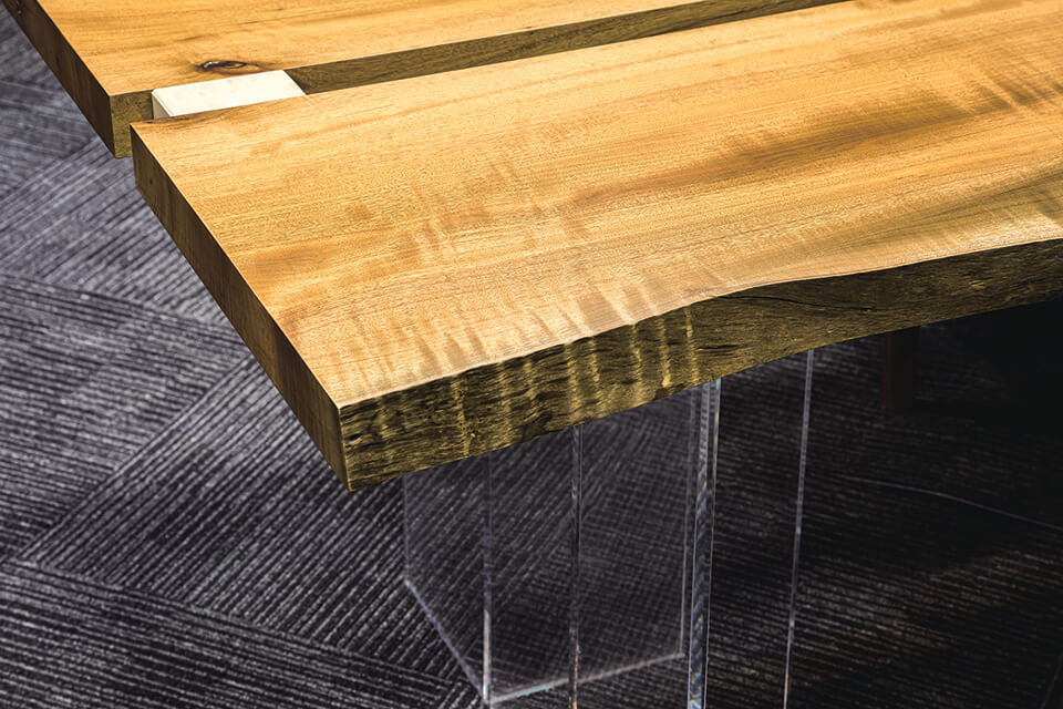 木材と石材という重厚感のある素材に対して、脚部にアクリルを用いて軽やかに仕上げたテーブル