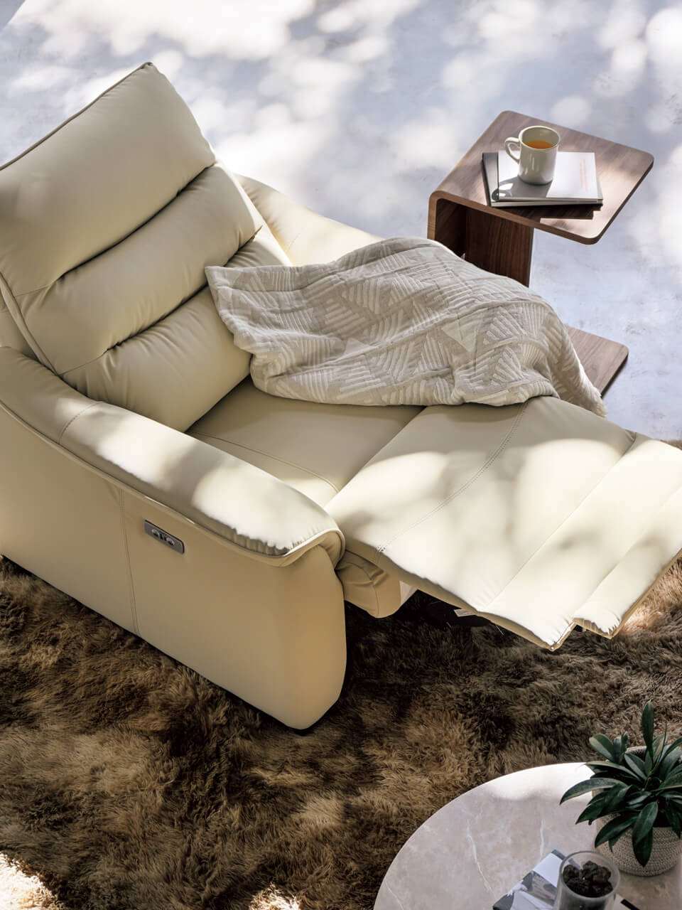 上/一人掛け電動リクライニングソファ「Nビリーバ3 Nシールド BE」の背もたれを倒した状態。側面のスイッチでリクライニングするほか、手動でヘッドレストの角度を調節可能。写真の製品は、キズや汚れに強い合成皮革「N・シールド」を張り地に採用したもの。USB電源も付属する