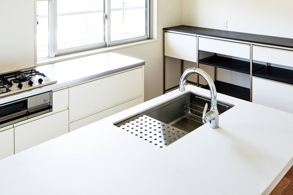 シンク側の天板は人造大理石、コンロ側はステンレス/バイブレーション仕上とし、機能性とメンテナンス性に配慮した