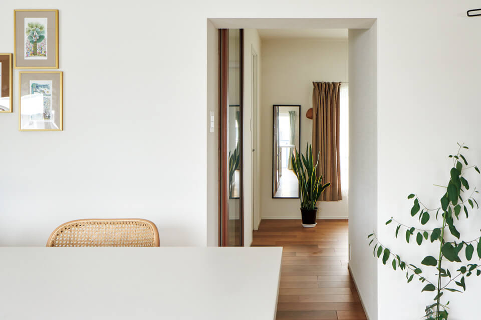 リビングから寝室を見る。建具を設けず連続した空間とすることで、視線の抜けと住まい全体の広がりを確保している