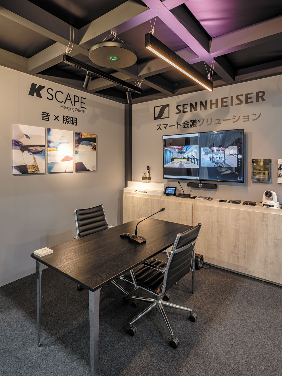 天井に埋め込まれた「Sennheiser」の集音マイク「TCC M」と「KSCAPE」のスピーカー内蔵照明「Rail」、ビデオバーを組み合わせたスマート会議ゾーン。会議室に機器を置かずにハイブリッド会議環境を整えられる提案だ